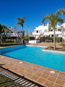 a swimming pool in front of a building with palm trees at Condado de Alhama N478 in Alhama de Murcia