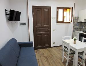 een woonkamer met een bank en een tafel en een keuken bij La Maiolica Blu in Trapani