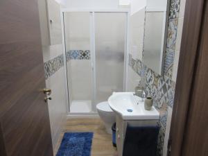 een badkamer met een douche, een toilet en een wastafel bij La Maiolica Blu in Trapani