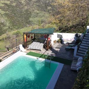 uma piscina com um gazebo ao lado em "Casa Ibero" Bubion, Alojamiento Turistico Rural em Bubión