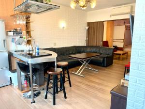 YokohamaKannai HouseBar في يوكوهاما: غرفة معيشة مع أريكة وطاولة