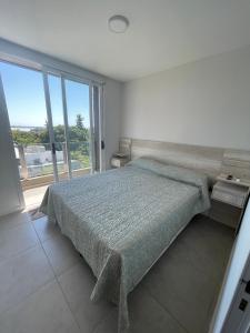 ein Schlafzimmer mit einem Bett und einem großen Fenster in der Unterkunft Departamento Parque in Paraná