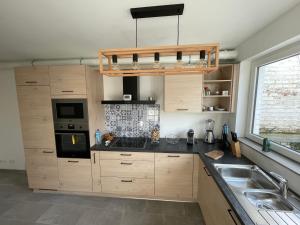 una cocina con armarios de madera y fregadero en Appartement avec extérieur à proximité de Liège, en Herstal