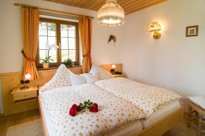 a bedroom with a bed with two roses on it at Haus Christl Reit im Winkl, Kostenloser Parkplatz, Spülmaschine, 5 Minuten zum Ortszentrum, ruhige Lage, Wlan in Reit im Winkl