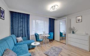 salon z niebieską kanapą i krzesłami w obiekcie Mieszkanie Spokojny Sopot w mieście Sopot