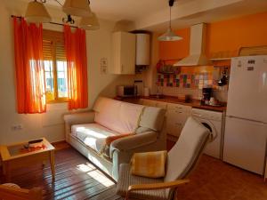 a living room with a couch and a kitchen at Apartamento Huerta Grande in Benaocaz