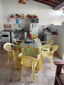 a kitchen with a table, chairs and a refrigerator at Pousada Solar Encanto do Marajó in Soure