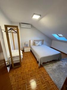 um quarto com uma cama e um espelho em Guest House TOWERCC em Figueiró dos Vinhos