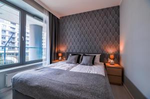 sypialnia z dużym łóżkiem i dużym oknem w obiekcie CITYSTAY Plac Unii Gdynia Apartment w mieście Gdynia