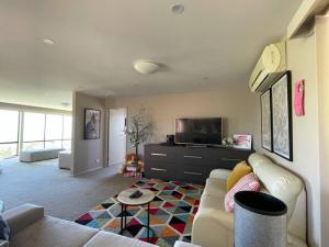 a living room with a couch and a tv at Hobart panoramic view with Spas in Hobart