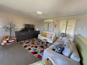 a living room with a couch and a tv at Hobart panoramic view with Spas in Hobart +11 photos