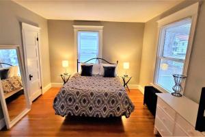 a bedroom with a bed and two windows at Welcome to Hat City Danbury, A Suburban Retreat in Danbury