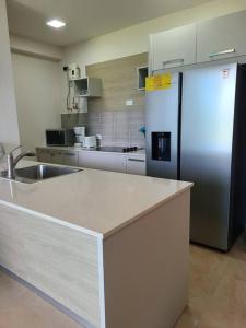 a kitchen with a refrigerator and a counter top at Fantastic Beach condo with pool and mountain views in Nueva Gorgona