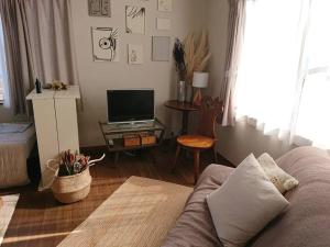 a living room with a couch and a tv at 香や野 kayano 海と富士山を一望できる1棟貸し宿 岡田港まで徒歩5分 in Oshima