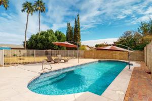 una piscina con 2 sillas y 2 sombrillas en Everlasting Phoenix en Phoenix