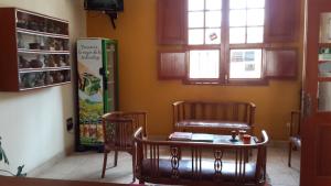 ピスコにあるHostal La Casonaの椅子2脚、テーブル、冷蔵庫が備わる客室です。