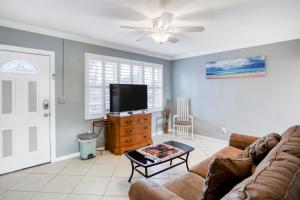 a living room with a couch and a flat screen tv at Bay Escape & Ocean Away in Clearwater Beach