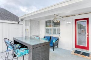 patio con mesa, sillas y puerta roja en Bay Escape & Ocean Away, en Clearwater Beach