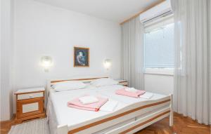 1 dormitorio con 1 cama con 2 toallas rosas en Amazing Apartment In Stari Grad With Kitchen, en Stari Grad