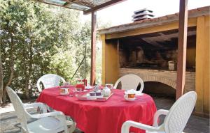mesa con sillas blancas y mantel rojo en Casa Grande, en Torricella