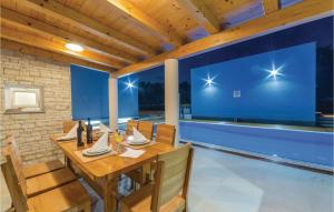 a dining room with a wooden table and chairs at Two-Bedroom Apartment In Verunic in Verunić