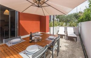 a wooden table with an umbrella on a patio at Cozy Apartment In Novigrad With Kitchen in Novigrad Istria