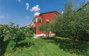 a red house with trees in front of it at Cozy Apartment In Novigrad With Kitchen in Novigrad Istria