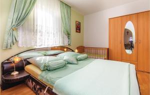 a bedroom with a bed with green sheets and pillows at Beautiful Apartment In Crikvenica With Wifi in Crikvenica