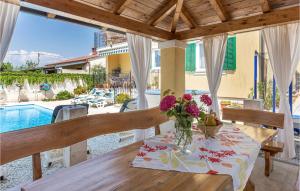 a dining room with a table and a view of a pool at Beautiful Apartment In Fondole With Outdoor Swimming Pool in Fondole