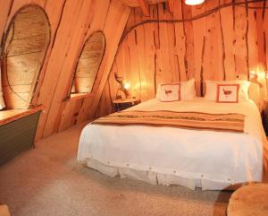 um quarto com uma cama num chalé de madeira em Huilo Huilo Montaña Mágica em Huilo Huilo
