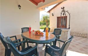 una mesa y sillas con un bol de fruta. en Holiday Home Hrboki Iii, en Hrboki 42 fotos más