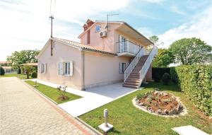 una casa rosa con una escalera en un patio en Holiday Home Hrboki Iii, en Hrboki