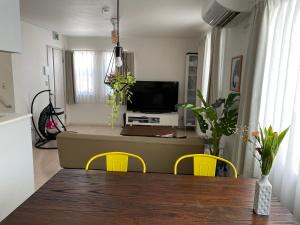 ein Wohnzimmer mit einem Tisch und gelben Stühlen in der Unterkunft Bayside in Hakodate