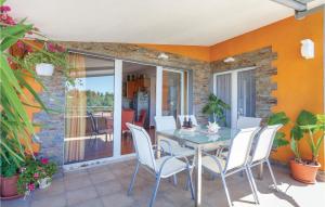 a dining room with a table and chairs on a patio at Cozy Apartment In Seget Vranjica With Wifi in Seget Vranjica