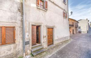 an old building with wooden doors on a street at Longino in Baschi