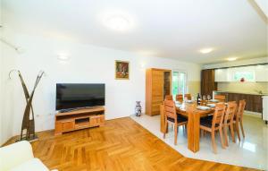 uma sala de jantar com uma mesa e uma televisão em Gorgeous Home In Trilj With Kitchen em Trilj