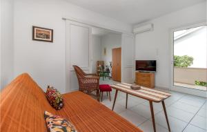 ドラマリにあるCozy Apartment In Dramalj With House Sea Viewのベッド1台、テーブル、リビングルームが備わります。