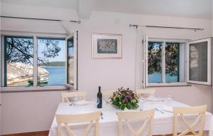 una sala da pranzo bianca con tavolo e sedie bianchi di Gorgeous Home In Zarace With House Sea View a Zarače