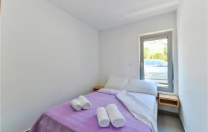 ein Schlafzimmer mit einem lila Bett mit zwei Paar Hausschuhen in der Unterkunft Amazing Apartment In Pag With Wifi in Pag