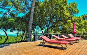 a row of lounge chairs and an umbrella on a deck at Amazing Home In Sauveterre With Wifi in Sauveterre