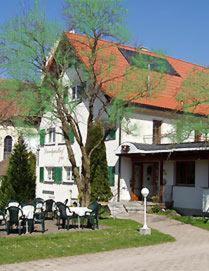 una casa con un albero di fronte a un edificio di Landgasthof zur Post a Heiligenberg