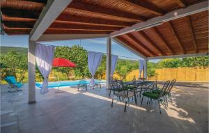 a patio with a table and chairs and a pool at Nice Home In Prolozac Donji With 3 Bedrooms, Wifi And Outdoor Swimming Pool in Donji Proložac