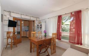 a dining room with a table and chairs and a window at Cozy Home In Lumbarda With Wifi in Lumbarda