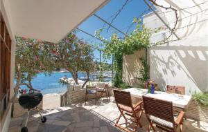 a patio with a table and chairs and the water at Cozy Home In Lumbarda With Wifi in Lumbarda