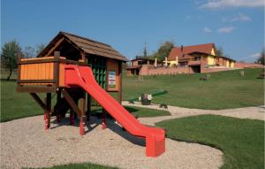 een speeltuin met een rode glijbaan voor een gebouw bij Beautiful Home In Repusnica With Sauna in Repušnica