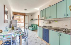 a kitchen with blue cabinets and a table with a tableablish at Acquamarina 65 in Rosapineta