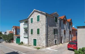 un antiguo edificio de piedra con persianas verdes en una calle en Amazing Home In Vodice With Kitchen en Vodice