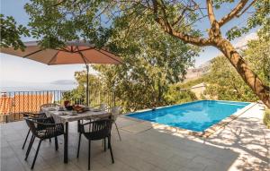 a patio with a table and chairs and a swimming pool at Cozy Home In Gornji Tucepi With Wifi in Tučepi