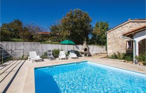 a swimming pool with two chairs and an umbrella at Pet Friendly Home In Martinjski With Kitchen in Martinski