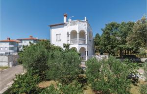 a white house on top of a hill with trees at Beautiful Apartment In Betiga With House Sea View in Barbariga